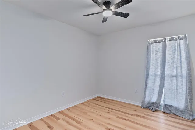 a view of a room with wooden floor and white walls