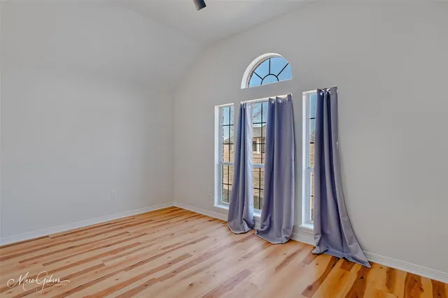 a view of a room with wooden floor and window