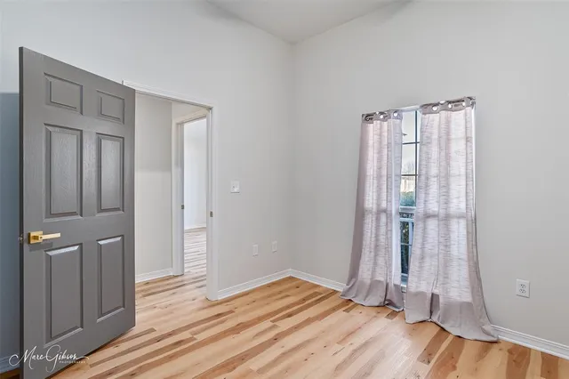 a view of empty room with wooden floor
