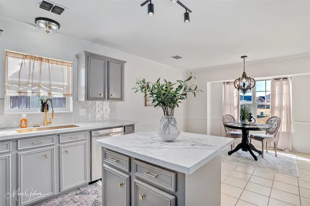 a kitchen with a sink a table and chairs in it