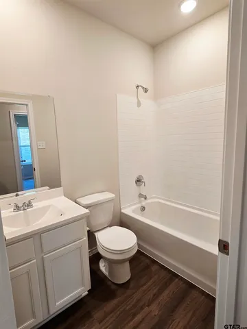 a bathroom with a sink a toilet a mirror and shower
