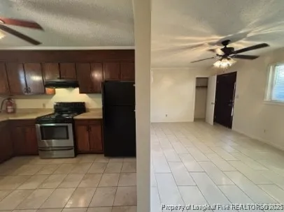 a kitchen with granite countertop a refrigerator and a stove top oven