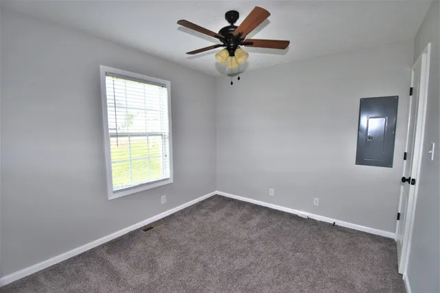 a view of an empty room and a chandelier fan