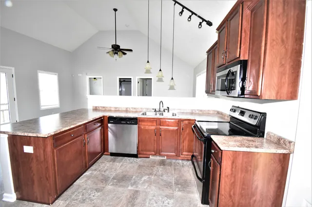 a kitchen with stainless steel appliances granite countertop a sink stove and refrigerator