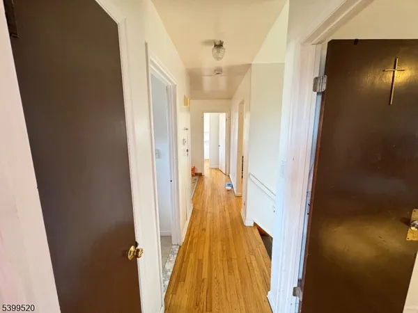 a view of a hallway with wooden floor and glass door