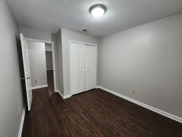 an empty room with wooden floor and a sink