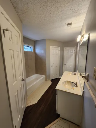 a bathroom with a sink a tub and a mirror