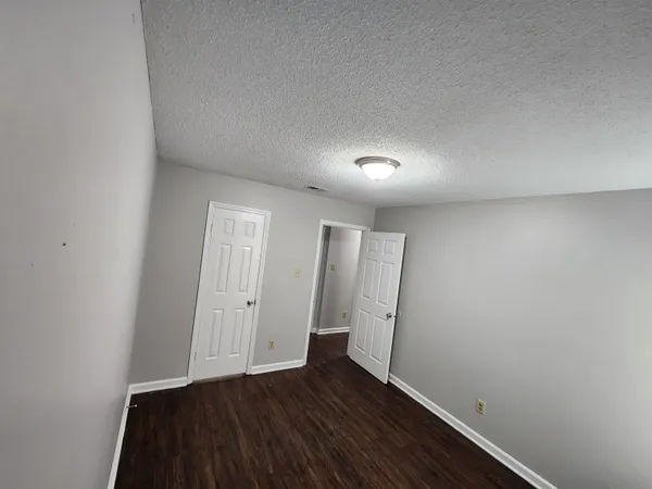 an empty room with wooden floor and mirror