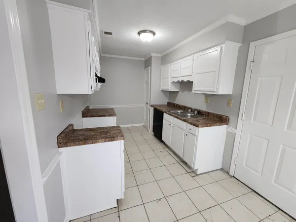 a kitchen with granite countertop white cabinets and white appliances