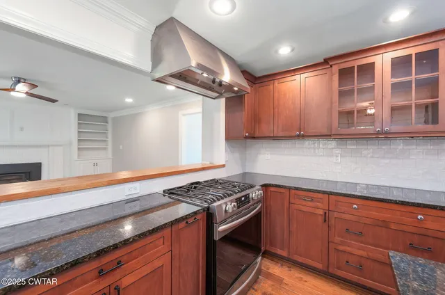 a kitchen with granite countertop cabinets stainless steel appliances and a counter space