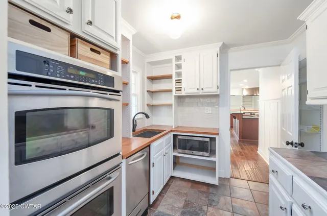 a kitchen with granite countertop a stove top oven and cabinets