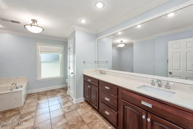 a spacious bathroom with a double vanity sink a mirror and a bathtub