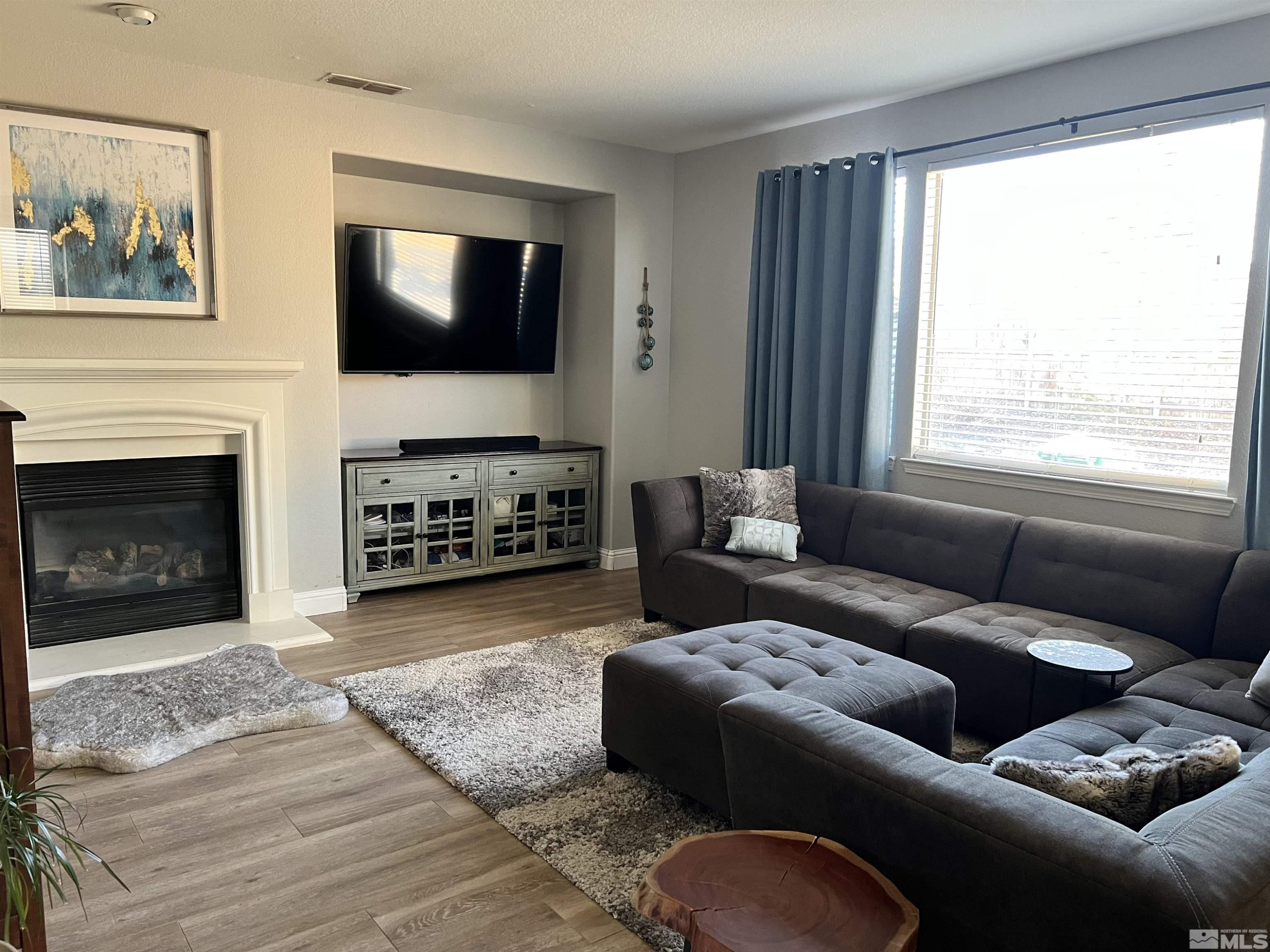 10640 Copper Lake Drive Reno, NV 89521 - Photo 3 of 18 a living room with furniture a flat screen tv and a fireplace