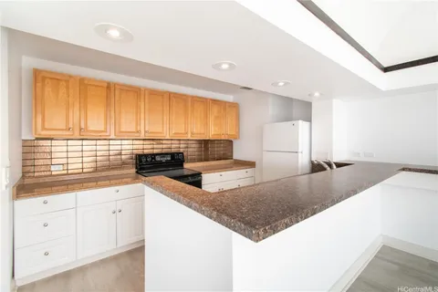 a kitchen with stainless steel appliances granite countertop a sink a stove and white cabinets