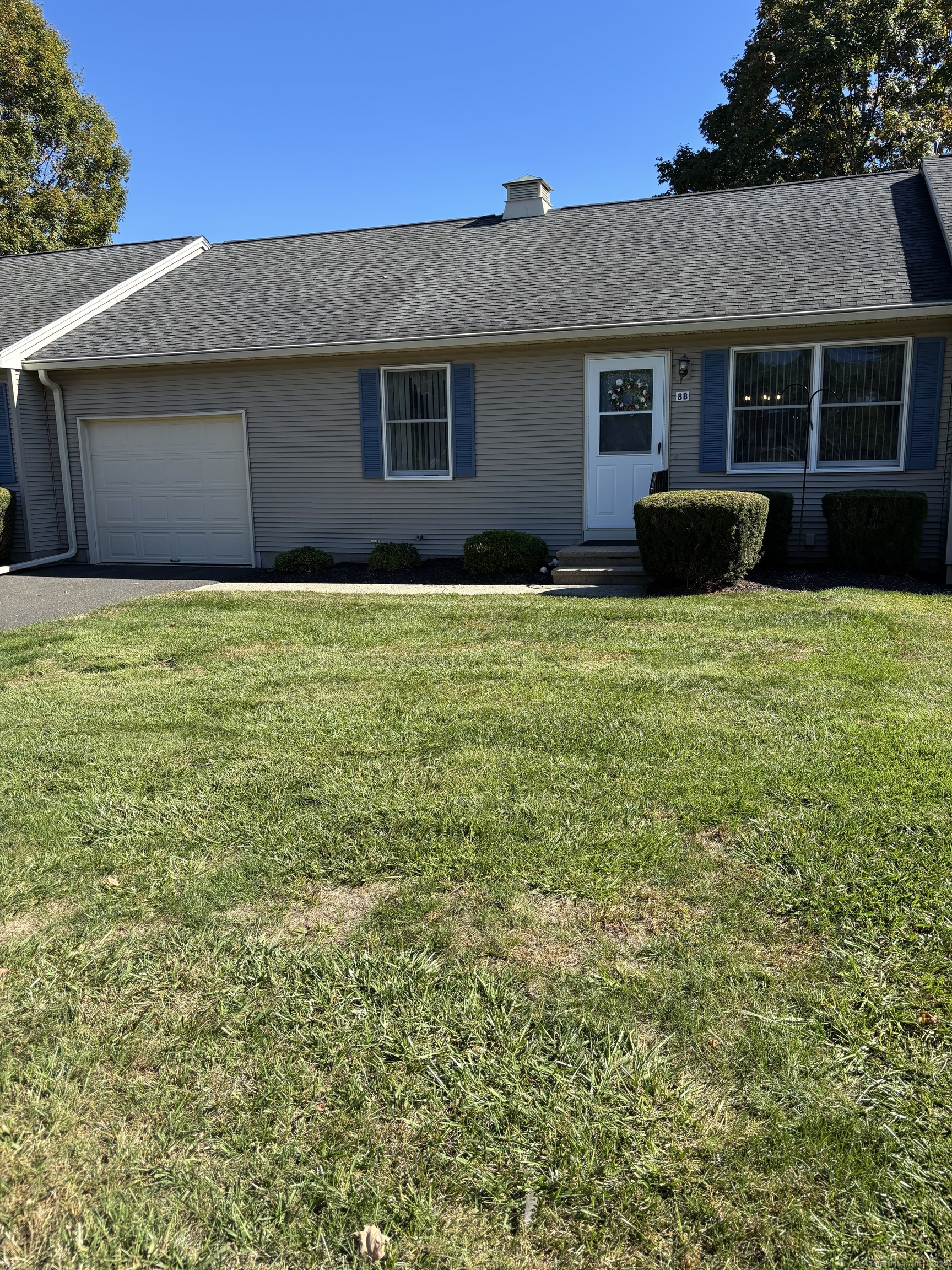 a front view of house with yard and trees