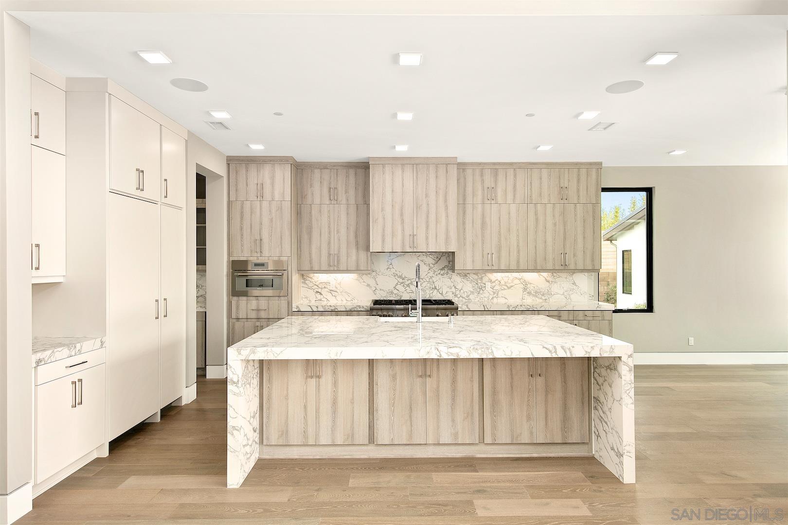 1817 Gwynn Drive Cardiff, CA 92007 - Photo 16 of 50 a large white kitchen with kitchen island granite countertop wooden cabinets a sink and a refrigerator
