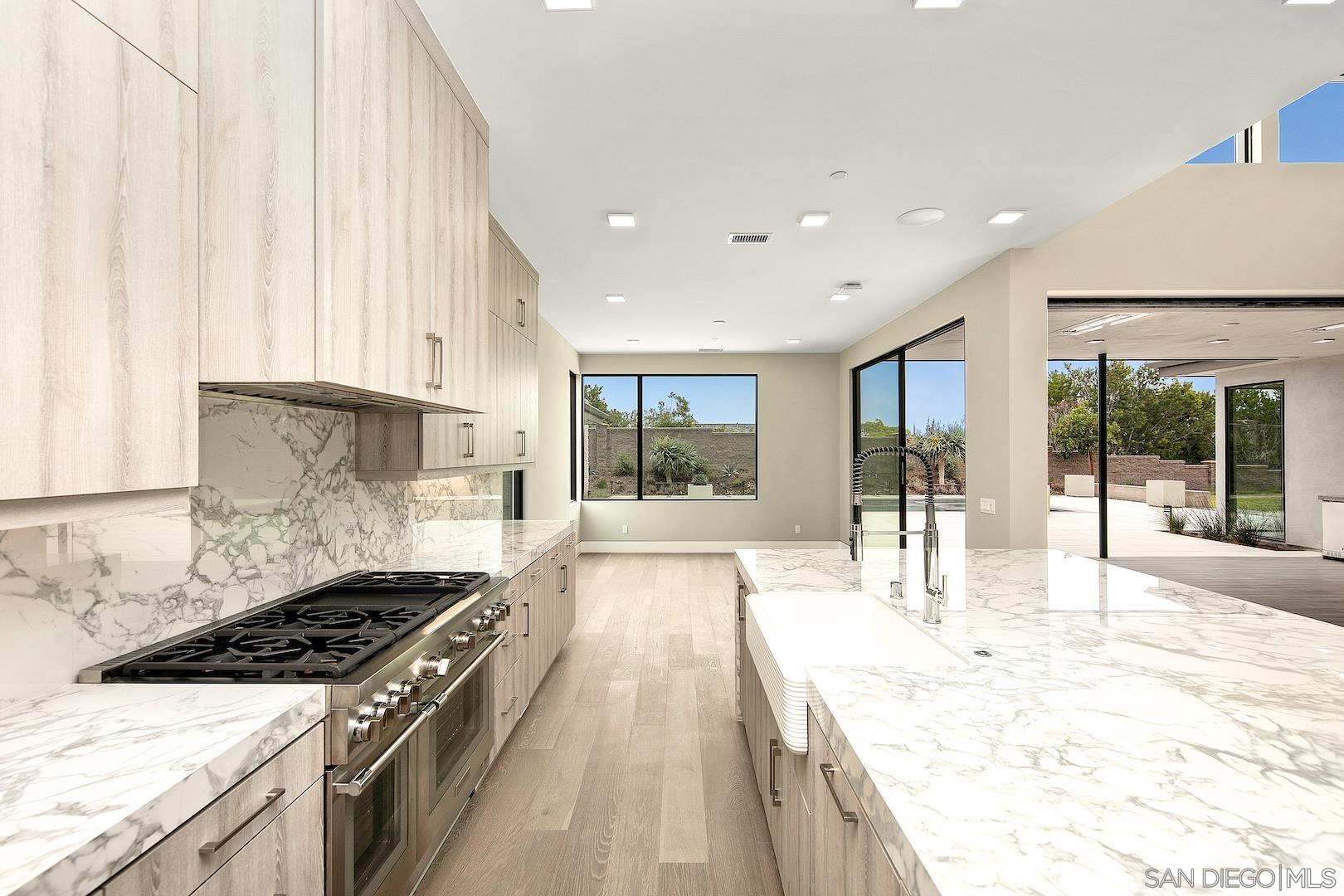 1817 Gwynn Drive Cardiff, CA 92007 - Photo 18 of 50 a large kitchen with kitchen island a large window a sink and stainless steel appliances
