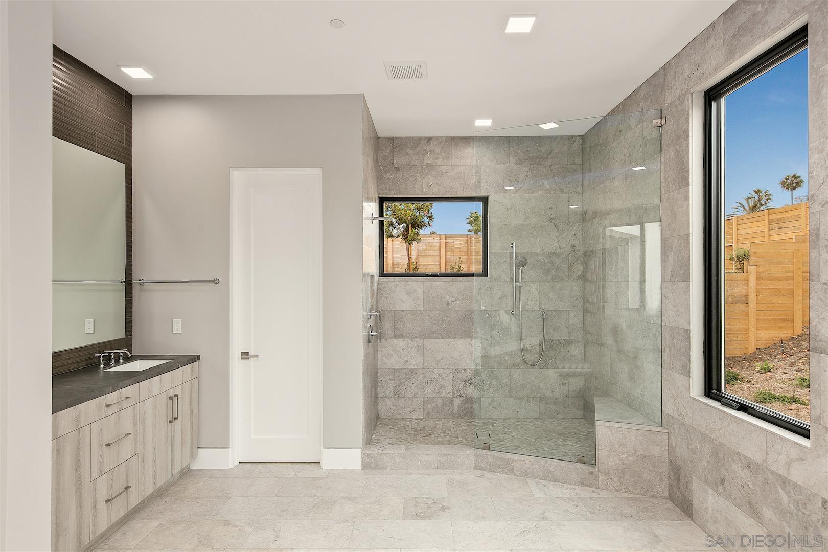 1817 Gwynn Drive Cardiff, CA 92007 - Photo 41 of 50 a bathroom with a granite countertop shower mirror and a sink