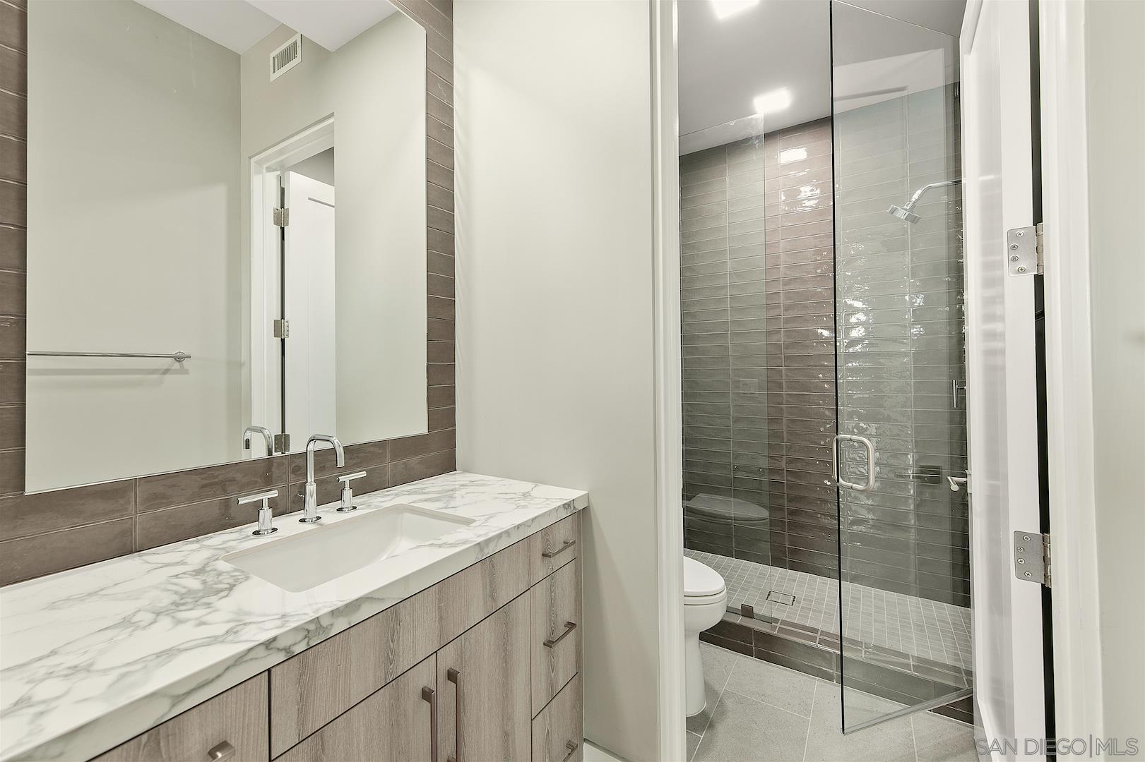 1817 Gwynn Drive Cardiff, CA 92007 - Photo 45 of 50 a bathroom with a granite countertop sink a toilet and shower