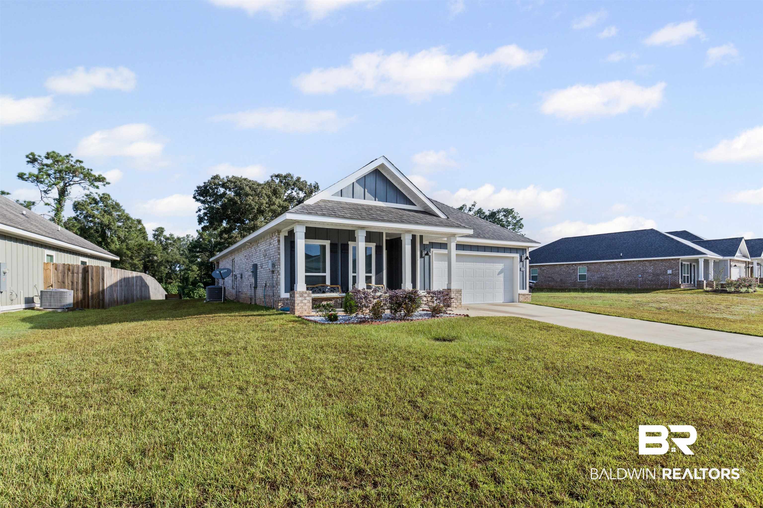 10564 Heirloom Road South Mobile, AL 36608 - Photo 3 of 24 Craftsman-style home with driveway, covered porch, brick siding, a garage, and board and batten siding