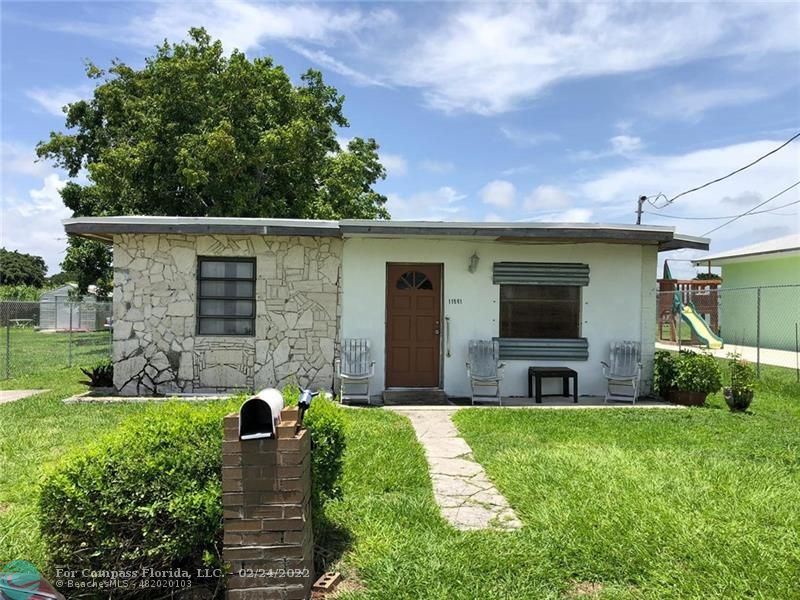 11961 Southwest 214th Street Miami, FL 33177 - Photo 1 of 1 a front view of house with yard and green space