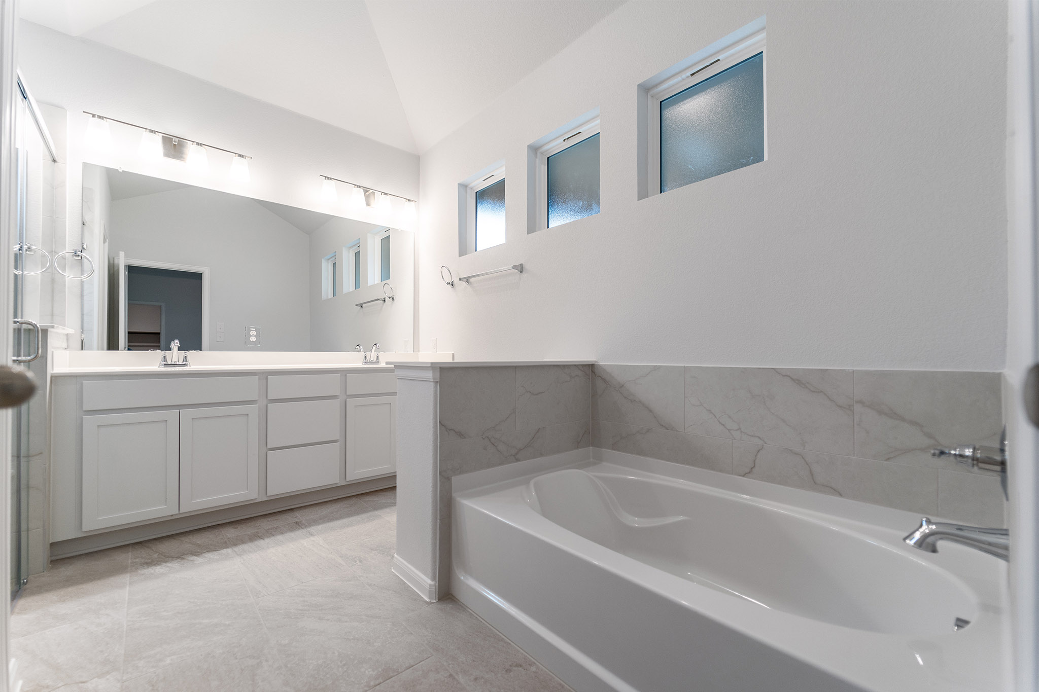 161 Mango Circle Buda, TX 78610 - Photo 15 of 22 a bathroom with a tub sink and mirror