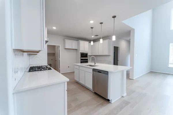 a kitchen with a stove a sink and a refrigerator