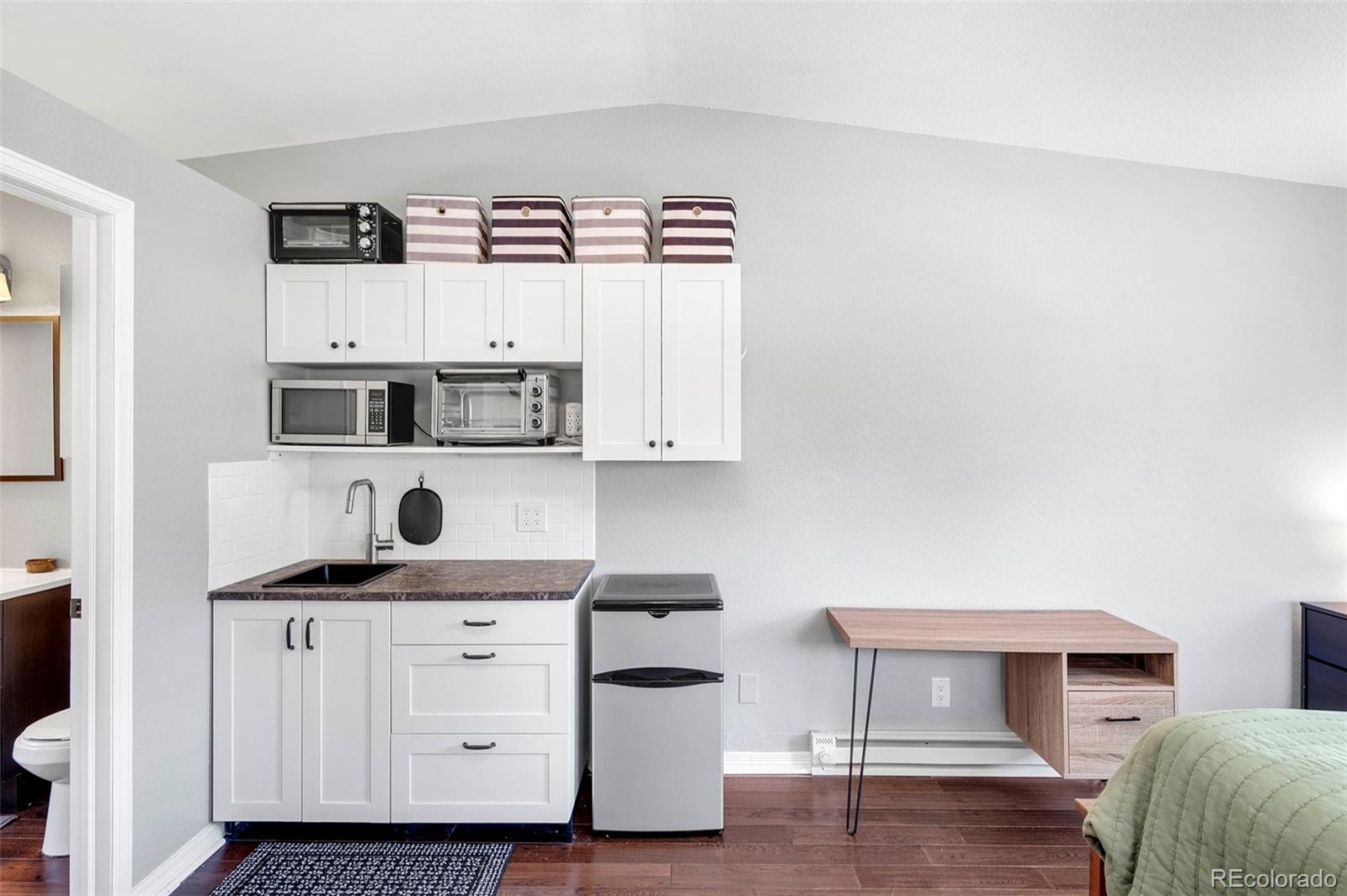 809 5th Street, Unit 201 Golden, CO 80403 - Photo 22 of 32 a view of kitchen with white cabinets and wooden floor