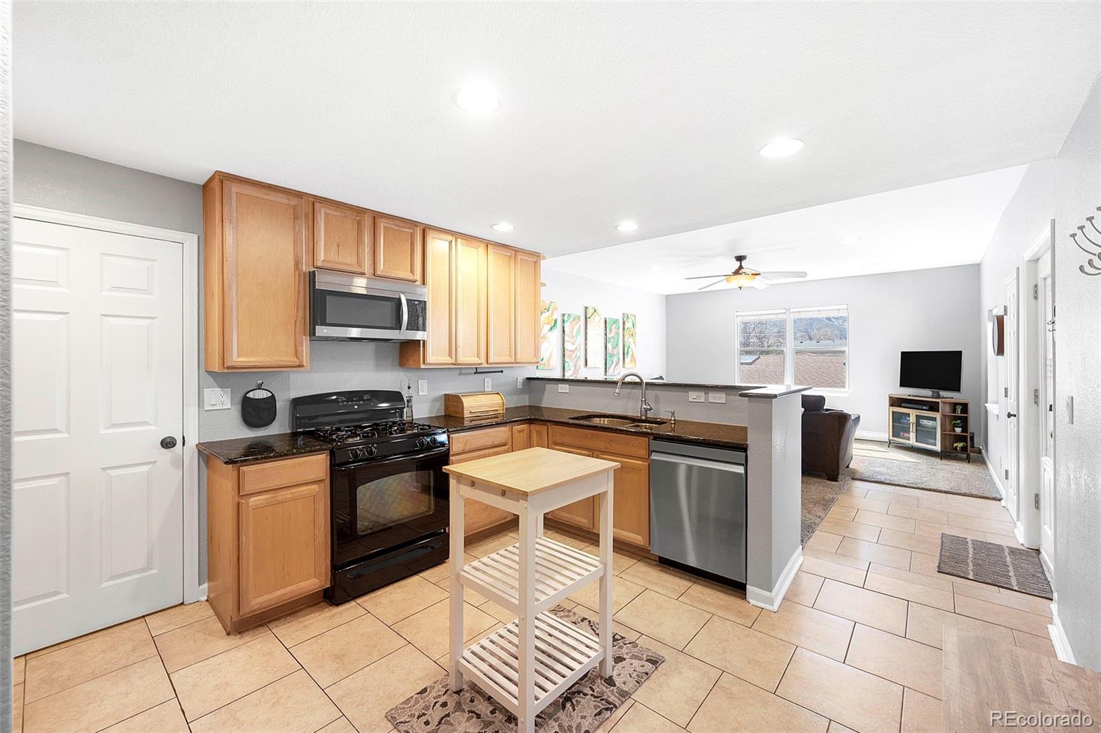809 5th Street, Unit 201 Golden, CO 80403 - Photo 7 of 32 a kitchen with stainless steel appliances granite countertop a stove top oven a sink a counter space and cabinets