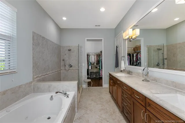 a spacious bathroom with a tub sink and mirror