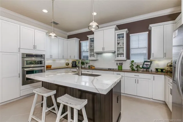 a kitchen with kitchen island granite countertop a sink counter top space appliances and cabinets