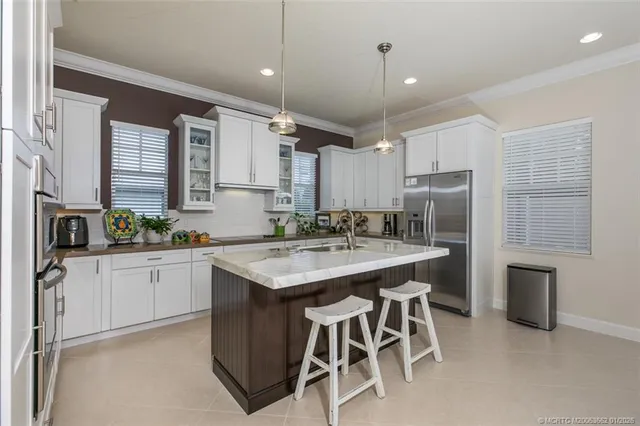 a kitchen with kitchen island a sink stove and refrigerator