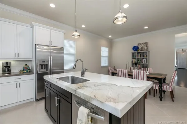 a kitchen with granite countertop a sink a center island and stainless steel appliances