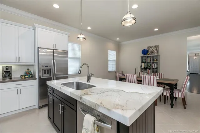 a kitchen with granite countertop a sink a center island and stainless steel appliances