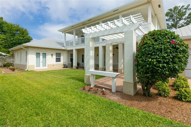 a view of a house with backyard and sitting area