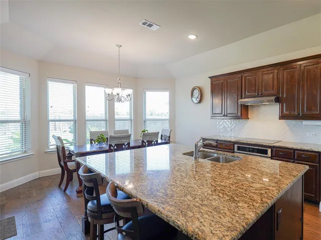 a kitchen with a table chairs and wooden floor