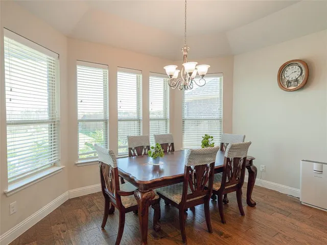 a view of a dining room with furniture a chandelier and wooden floor