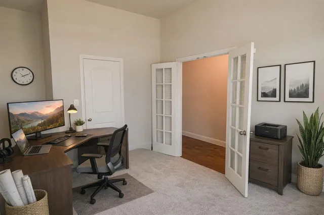 a view of a workspace with furniture and a window