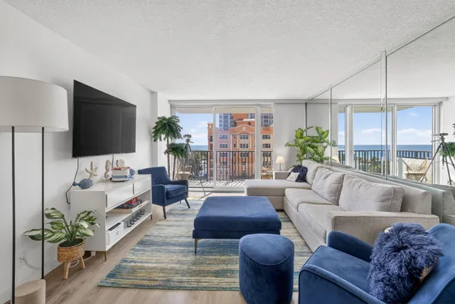 a living room with furniture flat screen tv and a large window