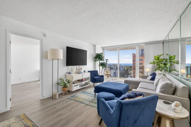 a living room with furniture a flat screen tv and a large window