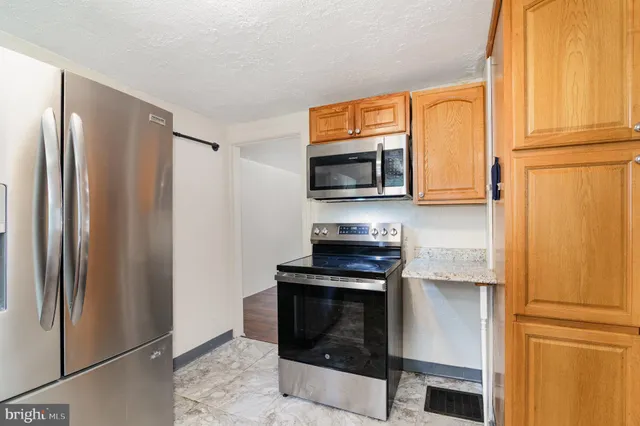 a kitchen with stainless steel appliances a refrigerator stove and microwave