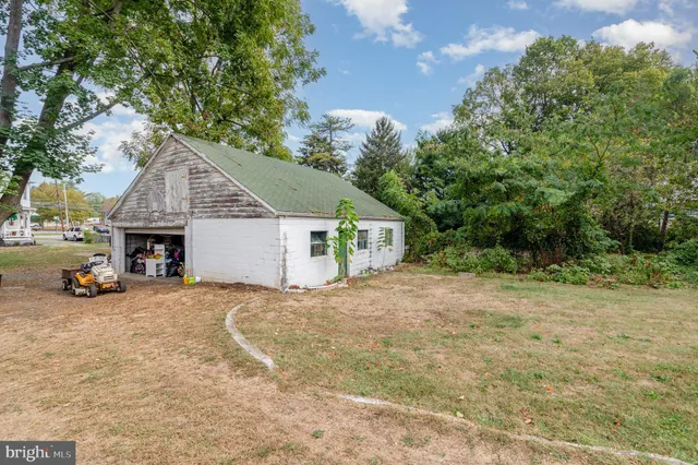 a front view of a house with a garden and trees