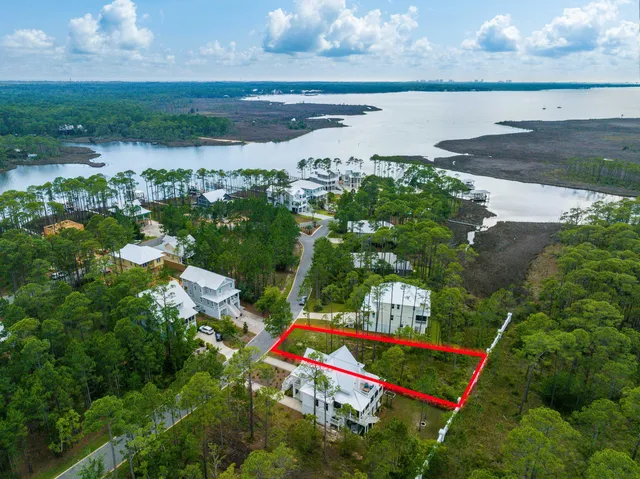 an aerial view of a house with a yard and lake view