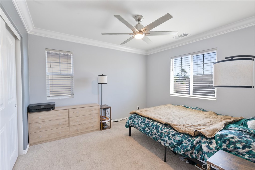 30283 Ramsay Drive Menifee, CA 92584 - Photo 18 of 24 a bedroom with a bed and a chandelier