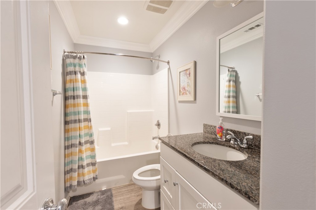 30283 Ramsay Drive Menifee, CA 92584 - Photo 19 of 24 a bathroom with a granite countertop sink toilet a mirror a vanity and shower