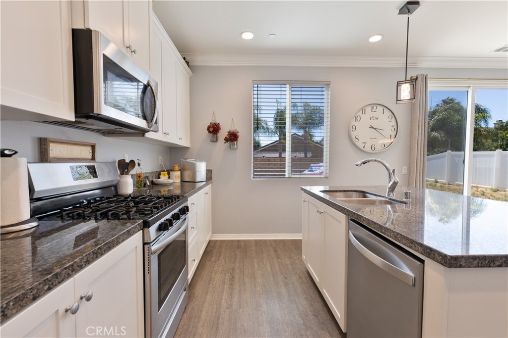 30283 Ramsay Drive Menifee, CA 92584 - Photo 7 of 24 a kitchen with stainless steel appliances granite countertop a sink stove and cabinets