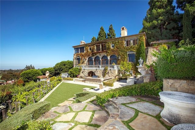 a view of a big yard with plants and large trees