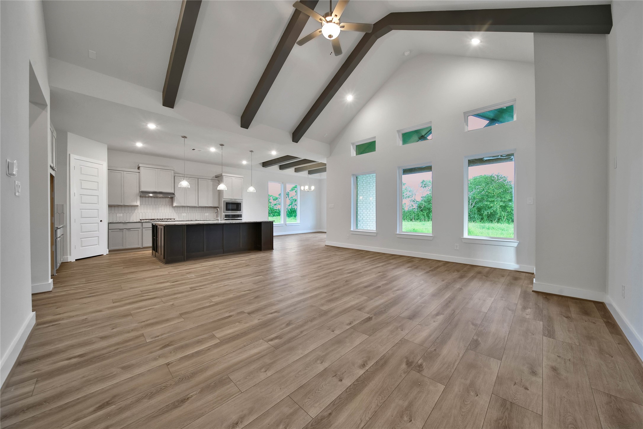 4602 Magnolia Bend Drive Rosharon, TX 77583 - Photo 6 of 39 an empty room with wooden floor and a kitchen
