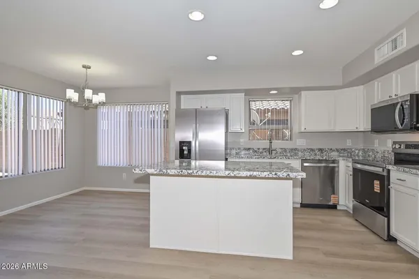 a kitchen with kitchen island granite countertop a sink and cabinets