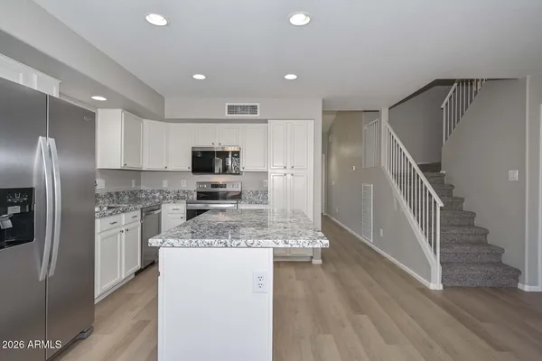 a kitchen with stainless steel appliances granite countertop a sink stove and refrigerator